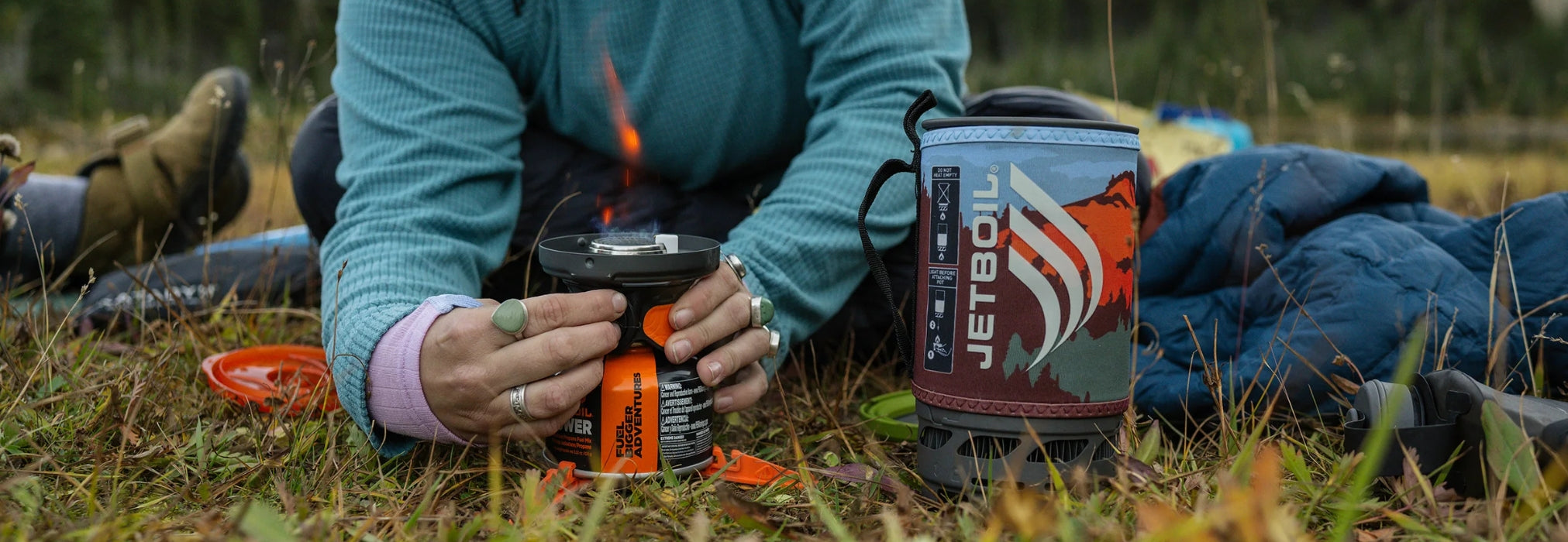 Person setting up a JetBoil stove outdoors